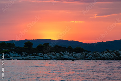 Panoramic view of coastline during sunset near Karydi beach, Vourvourou, Sithonia, Chalkidiki (Halkidiki), Greece, Europe. Vacation summer at Aegean Mediterranean Sea. Romantic atmosphere. Seascape photo