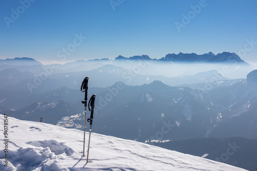 Hiking stick in snow. Scenic view from summit Freiberg on misty snow capped mountain peaks in Karawanks mountains, Carinthia, Austria. Winter wonderland on sunny day in Austrian Alps, Europe. Ski tour © Chris