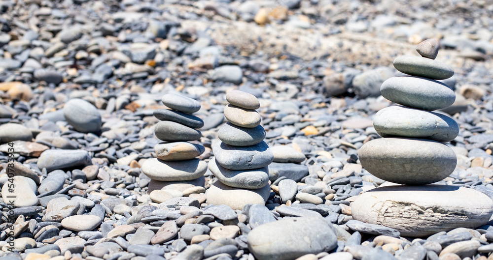 Pebbles on the seashore are stacked in a pyramid. Rest and relaxation, a sense of balance. Pebbles on the seashore are stacked in a pyramid. Rest and relaxation, a sense of balance.