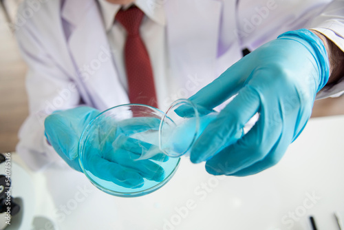 Biologist sits at table with test tubes. Work in quality inspection laboratory on laboratory