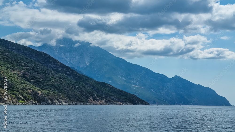 Boat tour with panoramic view over the Mediterranean Aegean Sea. Looking the coastline of peninsula Athos, Chalkidiki, Central Macedonia, Greece, Europe. Discover Mount Athos (Again Oros). Vacation