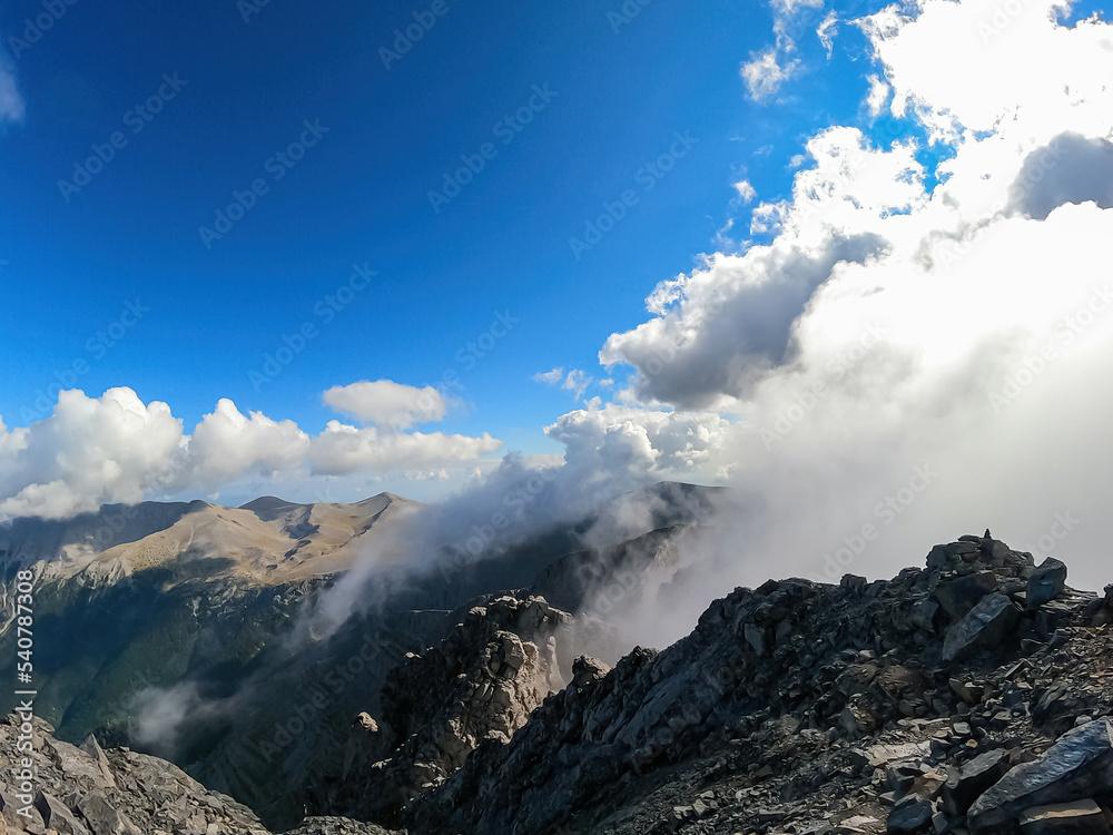 Panoramic view from cloud covered mountain summit of Mytikas Mount Olympus, Mt Olympus National Park, Macedonia, Greece, Europe. Home of the Ancient Greek gods. Hiking trail from Skala and Stefani