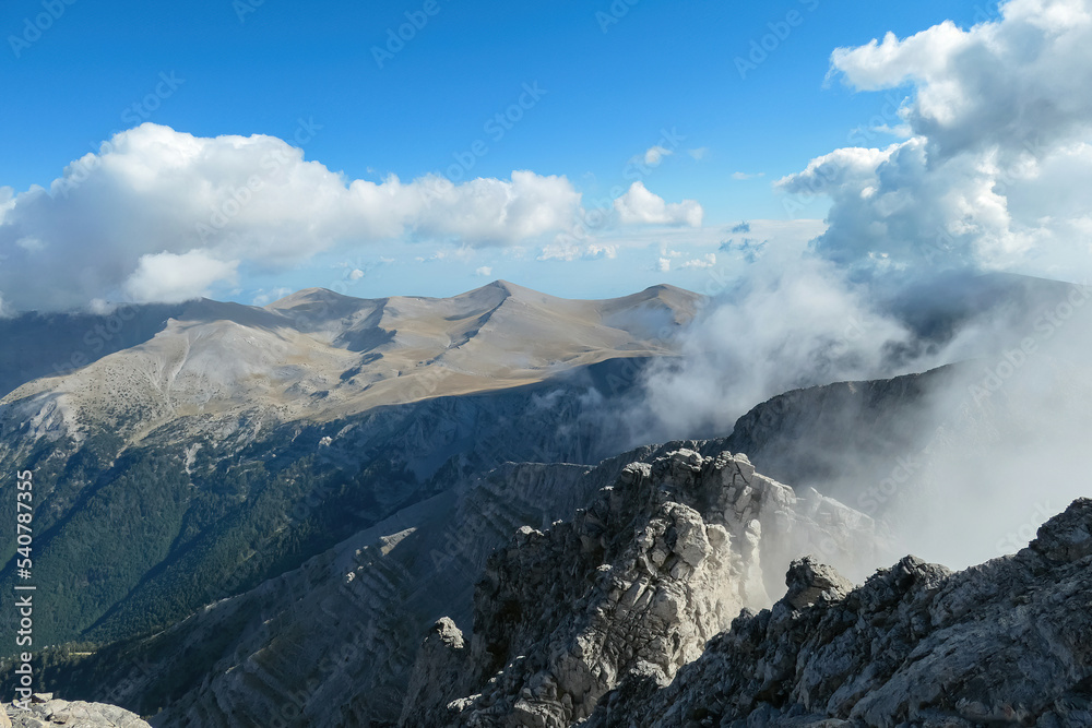 Panoramic view from cloud covered mountain summit of Mytikas Mount Olympus, Mt Olympus National Park, Macedonia, Greece, Europe. Home of the Ancient Greek gods. Hiking trail from Skala and Stefani Panoramic view from cloud covered mountain summit of Mytikas Mount Olympus, Mt Olympus National Park, Macedonia, Greece, Europe. Home of the Ancient Greek gods. Hiking trail from Skala and Stefani