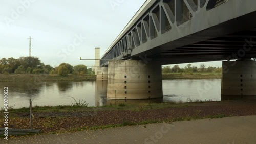 View of the concrete pillars of a trough bridge from below on the river bank