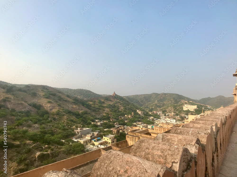 Jaipur, India, November 2019 - A view of a stone building with a mountain in the background