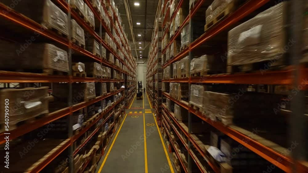 High racks with cardboard boxes and forklift loader in spacious warehouse first point view. Plant products storage