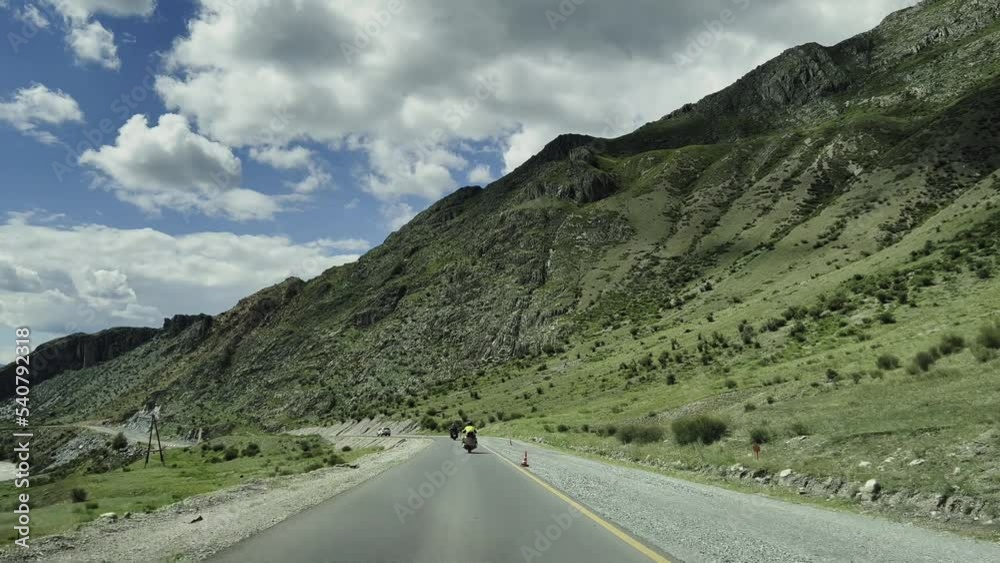Bikers ride motorcycles on a mountain serpentine with a picturesque landscape. Slow motion video. High quality 4k footage
