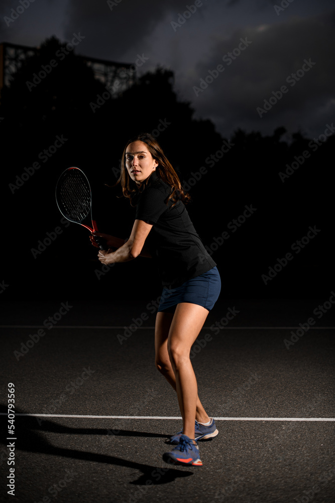 full length portrait of woman tennis player on the outdoor tennis court with racket in her hand.