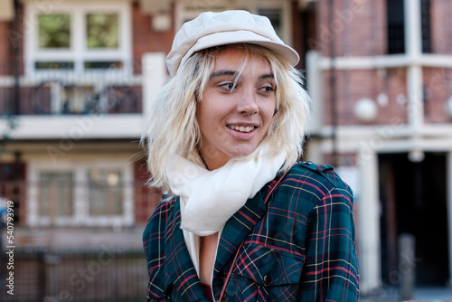 Smiling young alternative woman is posing in front of a old building. photo