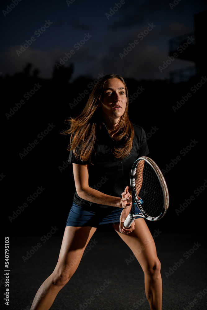 Close-up of athletic woman with racket in special pose which preparing to playing tennis Close-up of athletic woman with racket in special pose which preparing to playing tennis