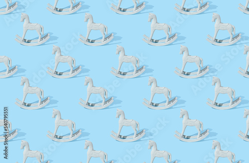 Pattern of handmade wooden toy horse on blue pastel background