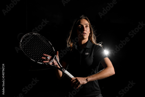 wonderful portrait of caucasian woman with brown hair in black tennis uniform with tennis racket