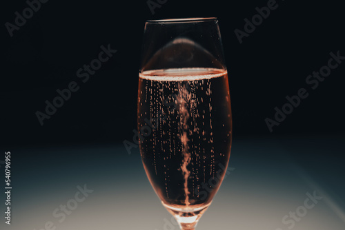 close up of glass of rose champagne. a glass of pink champagne with bubbles. the bubbles of a pink champagne in motion