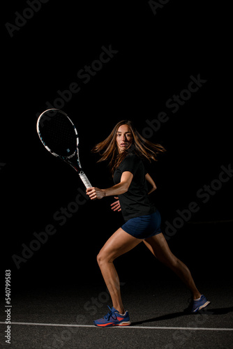 side view of sports female tennis player with tennis racket in her hand. © fesenko