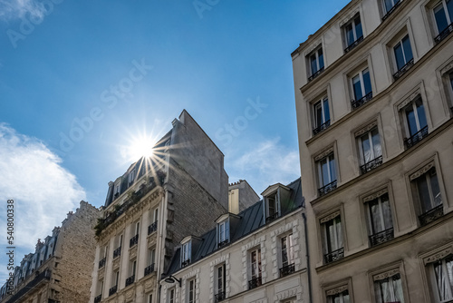 Paris, typical facades, beautiful buildings in Montmartre, sun’s rays 