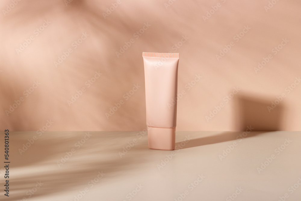 Cosmetic cream or mask in a white tube with hard shadows from the leaves on a white background. Natural organic care for face and body skin. View from above. Cosmetic cream or mask in a white tube with hard shadows from the leaves on a white background. Natural organic care for face and body skin. View from above.