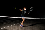 great shot of tennis ball in air and female tennis player with racket ready to hit it