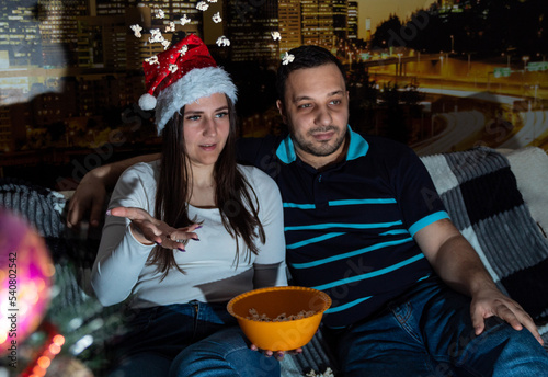 Couple is watching movie, woman is scattering popcorn. Selective focus. Picture for website about family, leisure.