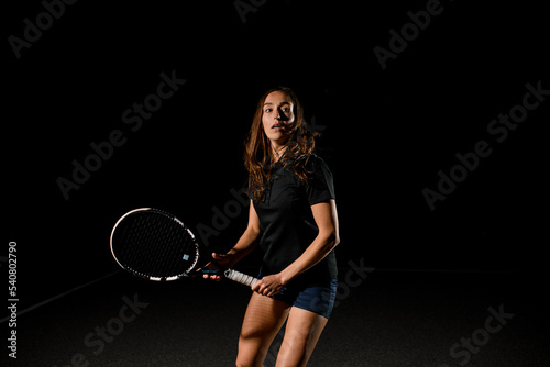 great view of sports woman with tennis racket in her hand. Training at outdoor tennis court.