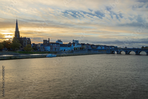 Maastricht, Netherlands 10-24-2022 Skyline of the Wyck area in downtown Maastricht with views on the iconic Servaas bridge and brewery. With a sunrise in Autumn coloring the sky in dramatic cloudscape
