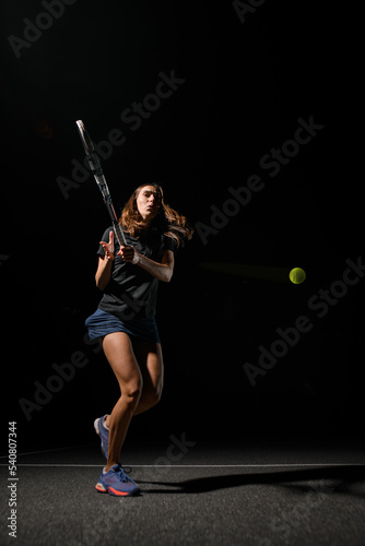 view of healthy woman with tennis racket and yellow tennis ball flying from her. © fesenko