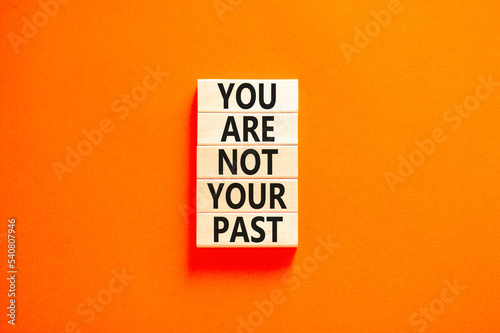 You are not your past symbol. Concept words You are not your past on wooden blocks. Beautiful orange table orange background. Business and you are not your past concept. Copy space.