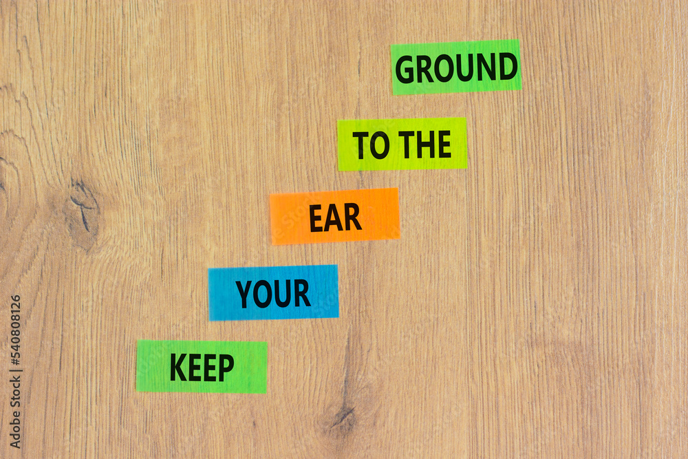 Keep your ear to the ground symbol. Concept words Keep your ear on the ground on colored paper. Beautiful wooden background. Business keep your ear on the ground concept. Copy space. Keep your ear to the ground symbol. Concept words Keep your ear on the ground on colored paper. Beautiful wooden background. Business keep your ear on the ground concept. Copy space.