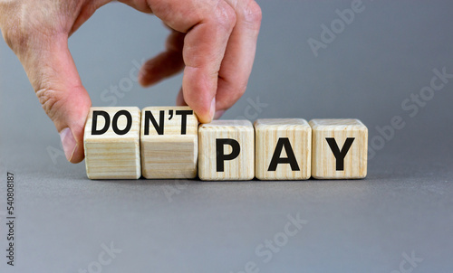 Do not pay symbol. Concept words do not pay on cubes. Businessman hand. Beautiful grey table grey background. Business, financial crisis and do not pay concept. Copy space.