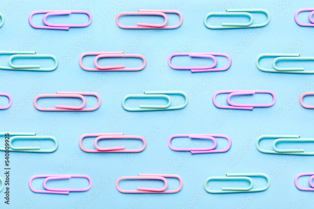 Multiple paperclip, flat lay group of objects on blue background Multiple paperclip, flat lay group of objects on blue background