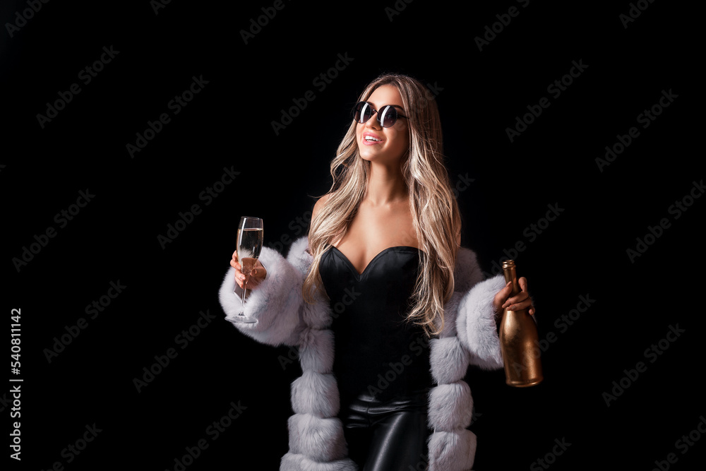 Luxury blonde girl in fur coat and sunglasses holds champagne while smiling celebrating something Luxury blonde girl in fur coat and sunglasses holds champagne while smiling celebrating something