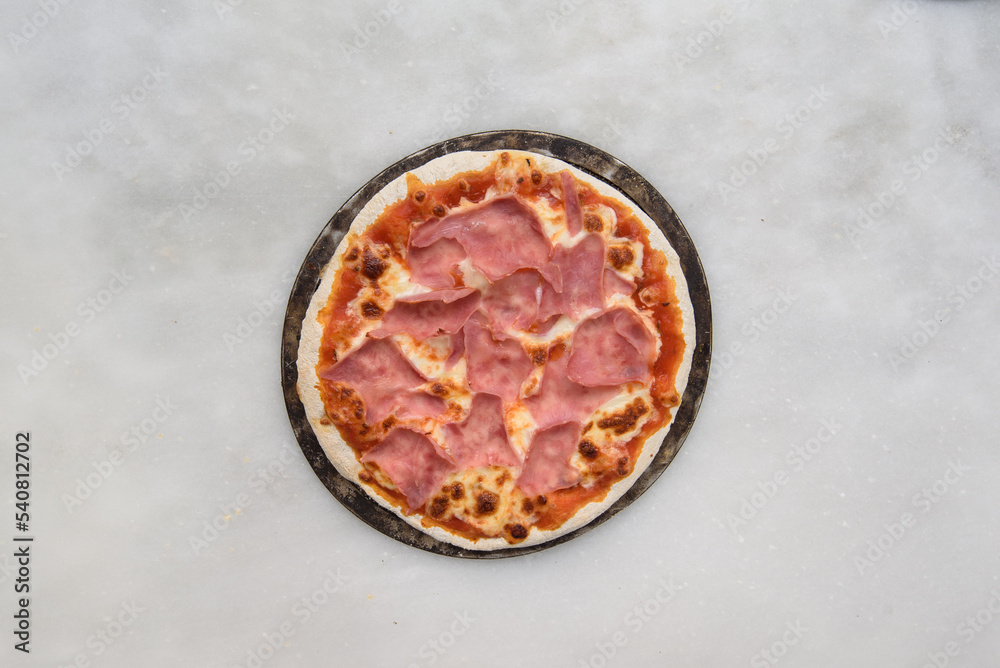 pizza prosciutto top view over a white stone