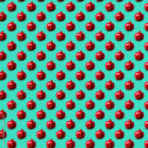 Seamless Pattern made with ripe pomegranate on green color background.