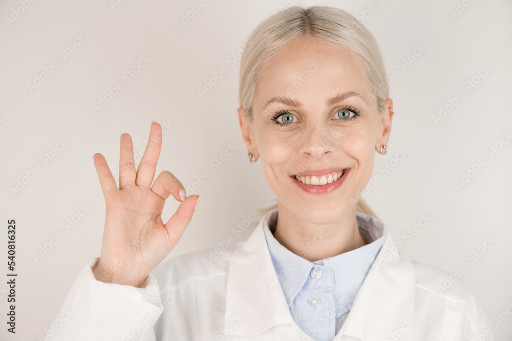 Portrait of a happy female doctor showing the OK sign