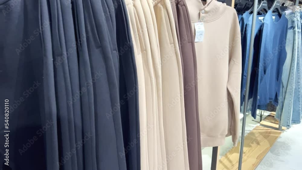 A collection of stylish men's clothing in the store. A person goes through a row of men's clothes and chooses visually what will suit him. Men's clothing for today's successful young man A collection of stylish men's clothing in the store. A person goes through a row of men's clothes and chooses visually what will suit him. Men's clothing for today's successful young man