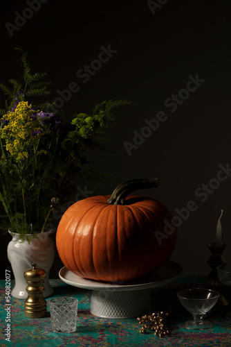Pumpkin over a decorated table and dark ambient