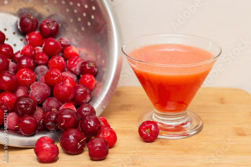 bowl filled with fresh acerolas next to acerola juice
