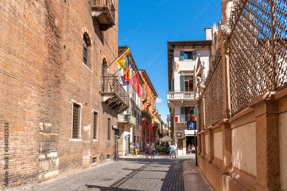 A street of shops and cafes in the historic medieval old town center of Verona, Italy.