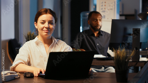 Portrait of woman analyzing executive data on laptop, using online research on network to create presentation. Working at night to plan professional report and do paperwork, send email.