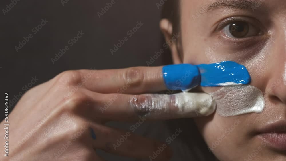 Supporter Painting Face and Looking at Camera. Football Fan Preparing for the Match. Colored Face with Flag Colors Blue and White. Slow Motion 4K Prores 422