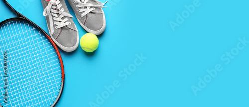 Tennis racket, shoes and ball on blue background with space for text