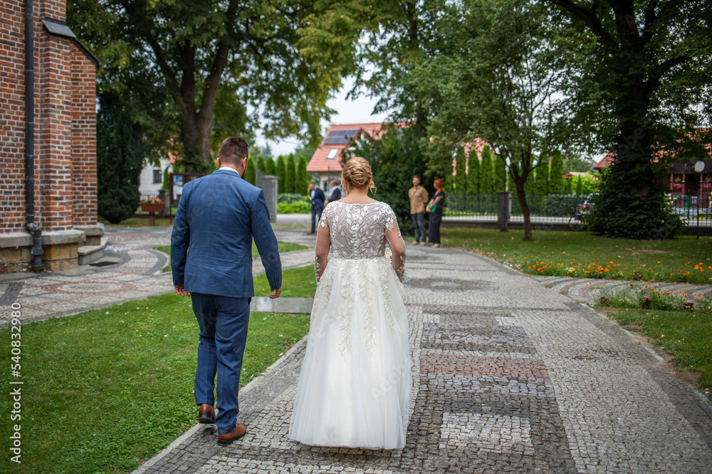 Para Młoda idzie do kościoła. The bride and groom are going to church. - obrazy, fototapety, plakaty 