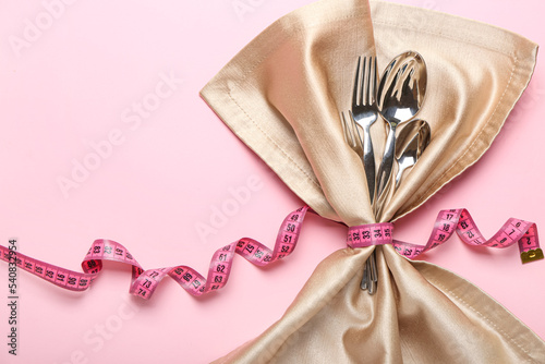 Fototapeta Napkin, cutlery and measuring tape on color background