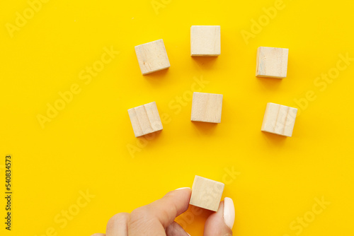 Close up Woman hand arranging wood block stacking as step stair.