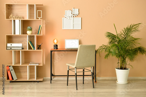 Cozy interior of modern workplace with laptop and family tree photo frame © Pixel-Shot