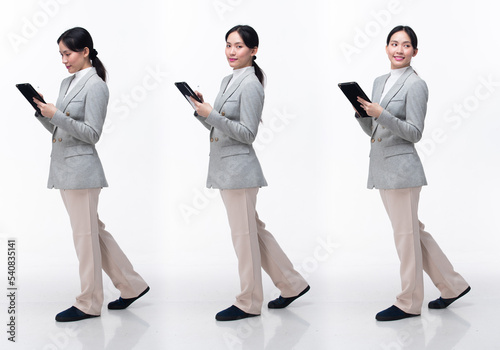 Full Length 20s Asian Woman wear formal business blazer suit dress pant shoes. Black long straight hair female hold tablet work confident, walking forward turn left right, white background isolated