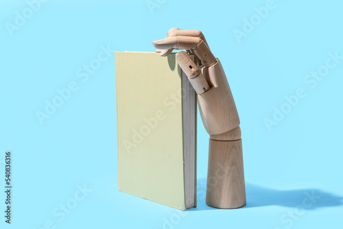 Wooden hand with book on bl...