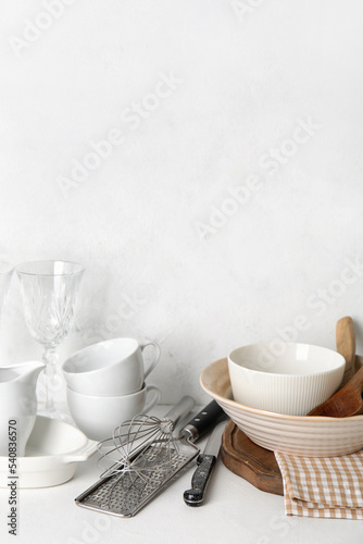 Set of different dishware and kitchenware on white table