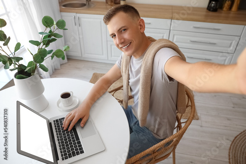 Young man with laptop takin...
