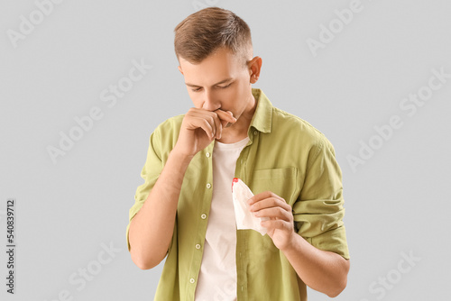 Young man with nosebleed an...