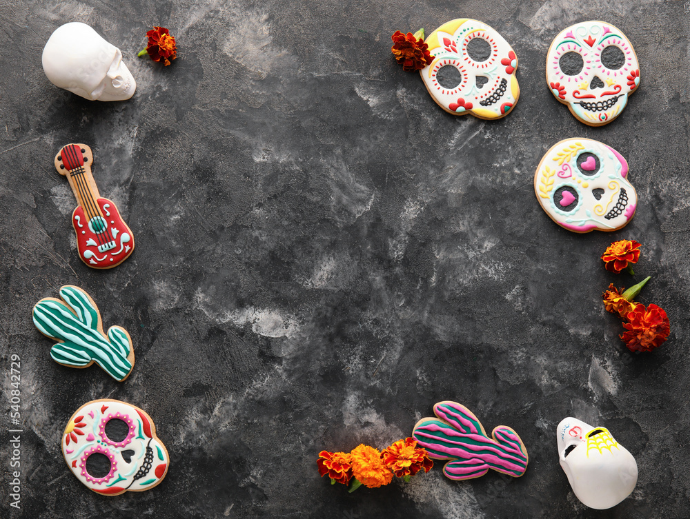 Frame made of cookies, skulls and flowers on dark background. El Dia de Muertos